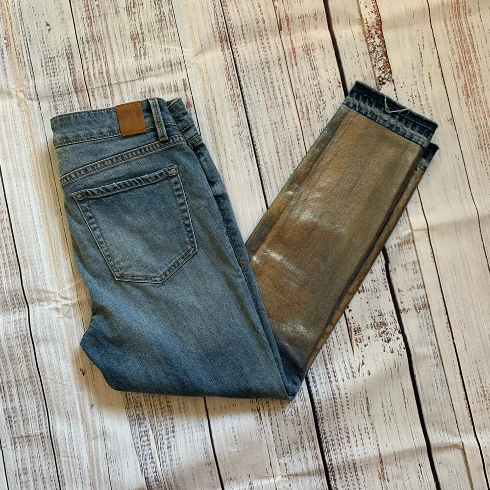 Level 99 jeans. Gold/silver design on bottom. Mid rise. Size 27.